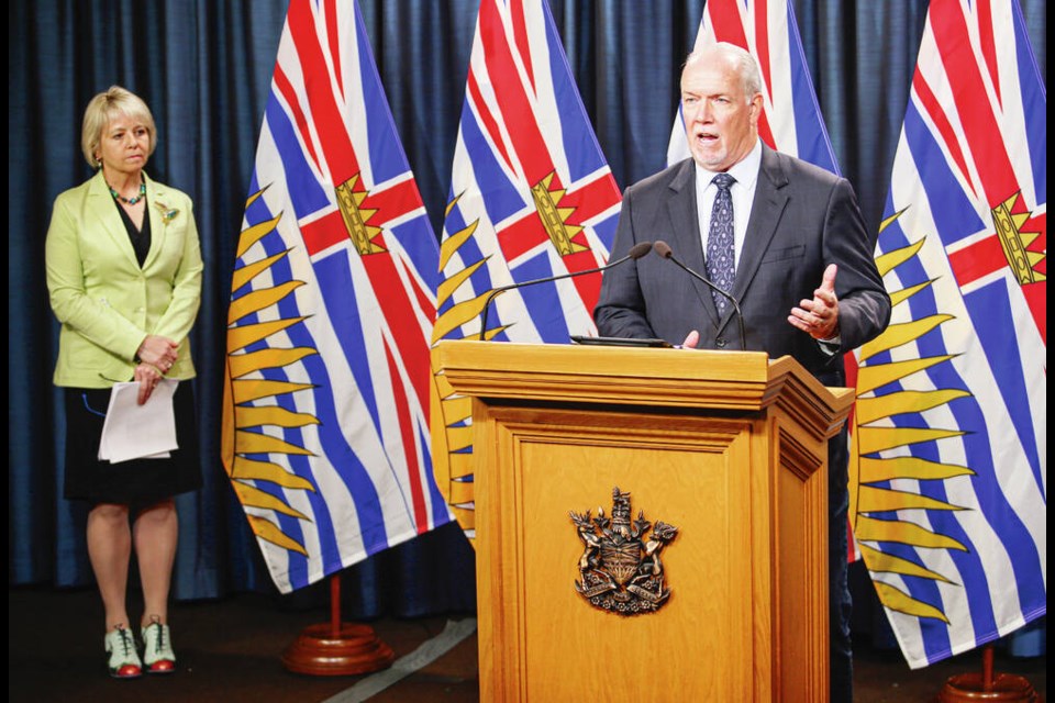 Premier John Horgan provides details of B.C.'s vaccine card program on Tuesday, Sept. 7, 2021, as provincial health officer Dr. Bonnie Henry looks on. ADRIAN LAM, TIMES COLONIST