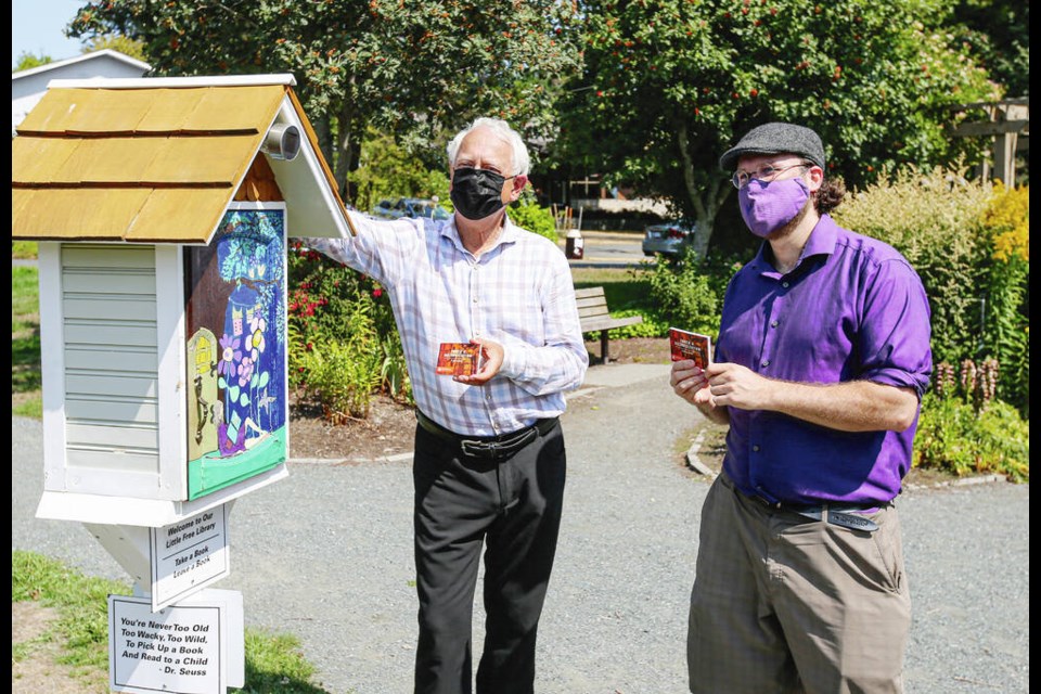 Murray Rankin, MLA for Oak Bay-Gordon Head and minister of Indigenous Relations and ­Reconciliation, left, and Greater Victoria Placemaking Network board member Teale Phelps Bondaroff deliver copies of Truth and Reconciliation: Calls to Action to a little free library in Maynard Park in Saanich in August. The network has now launched the Little Free Library Truth and Reconciliation Book Project. ADRIAN LAM, TIMES COLONIST