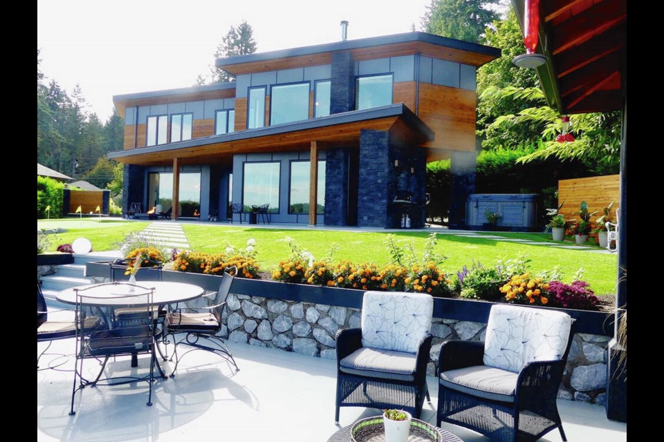 The owners of this Shawnigan Lake waterfront home built it on a property they have owned for 15 years to take in the lake views, and went with a modern design that has many angles — not only in the home but outside, such as the angled walkway to the lower patio sitting area and to the angled side fence.