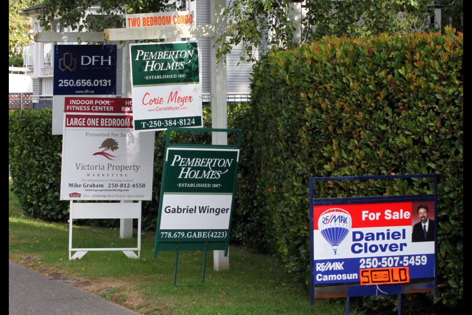A large grouping of For Sale real estate signs along Burnside Road West near Eldon Place.