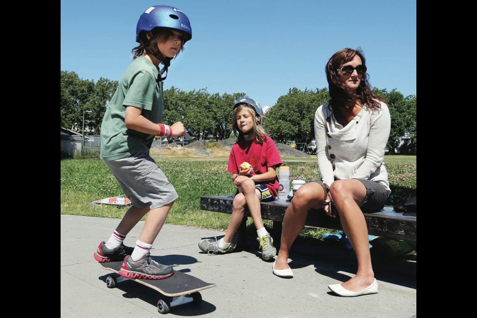 Tamara Lukie watches as her sons Oscar, 8, left, and Callym, 10, skateboard at the Vic West skate park.