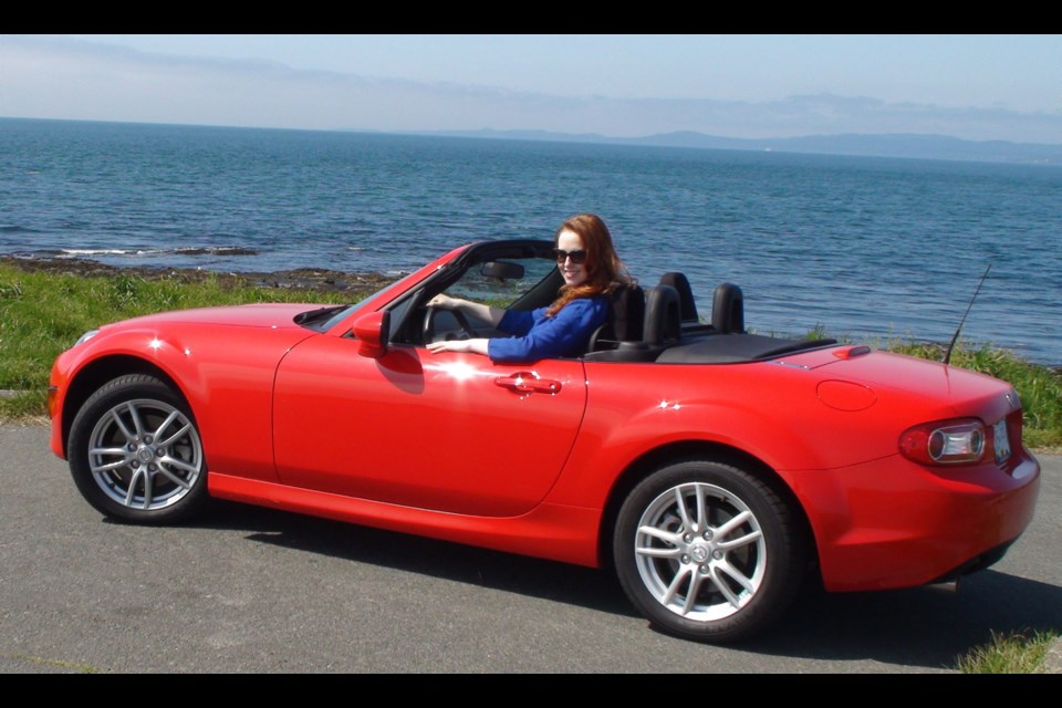 Amanda Lisman strokes a sporty pose in a scarlet Mazda Miata. The star of Blue Bridge Repertory Theatre's production of My Fair Lady, which opens Aug. 6, is helping promote a fundraiser for the theatre company's capital campaign. They are raffling off the little red two-seater, with ticket sales ending in late August.