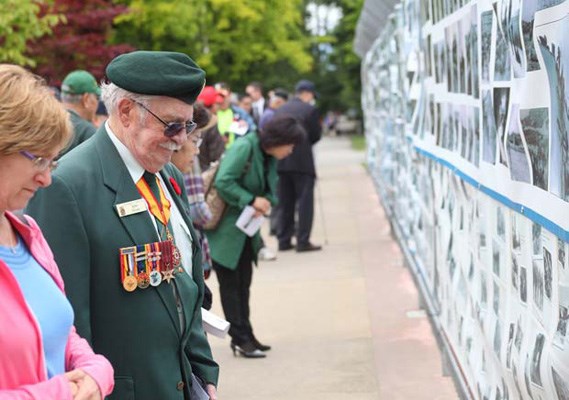 Korean War Veteran Ralph DeCoste at a wall adorned with photos from the Korean War at Burnaby Central Park, where Port Moody resident Guy Black finished the end of a two-day, 82-kilometre walk to remember the conflict.
