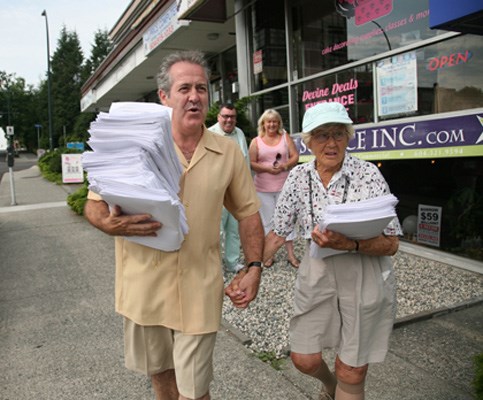James Crosty and Alice Thompson carry 15 bundles of petitions down Sixth Street to New Westminster city hall before Tuesday's 4:30 p.m. deadline.