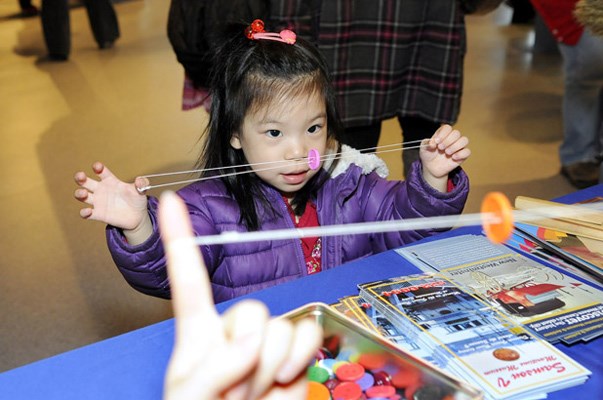 Alena Wing, four, learns to make a buzz button toy at the NW Museum and Archives table during Family Day celebrations Feb. 11 at the Fraser River Discovery Centre.