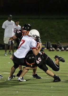 Captains Michael Desjarlais (no. 66) and Makoto Brennan (#60) lay the hurt on one Bear as they sack Mt. Boucherie quarterback Joe Court for a loss.