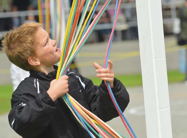 Watching: May Day observers came prepared for all weather Wednesday at Queen's Park Stadium.
