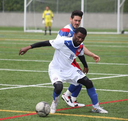 The heat is on: Ruffin Lumbala, front, of Estrella de Chile's premier men's team protects the ball from a Kamloops Heat defender in a 2-2 draw in Pacific Coast Soccer League play Saturday.