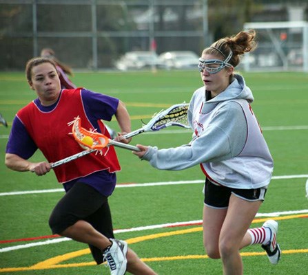 Having fun: New Westminster, in red, and Burnaby bring out the fun side of field lacrosse in an under-19 girls' matchup at Burnaby Lake Sports Complex-West last Saturday.
