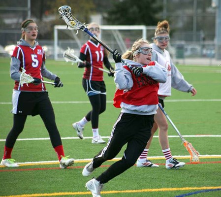 Having fun: New Westminster, in red, and Burnaby bring out the fun side of field lacrosse in an under-19 girls' matchup at Burnaby Lake Sports Complex-West last Saturday.