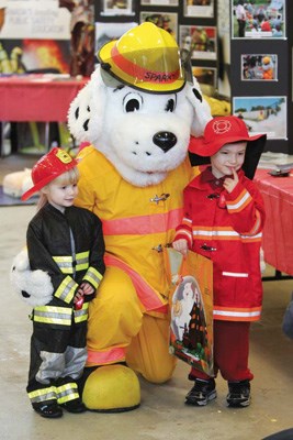 Wee firefighters: Two-year-old Rebecca Hiebert and her brother James pose with Sparky at the New Westminster Fire and Rescue Service's Oct. 13 open house at the Glenbrook fire hall. They donned their firefighters' costumes for the festivities.