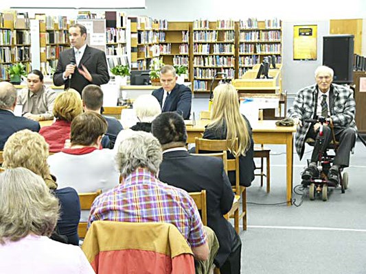 School trustee candidate Dave Phelan, standing on right, answers a question during Thursday night's school trustee all-candidates meeting in the NWSS library. To the far right, in the scooter, is school board and council candidate James Bell, who provided some of the most entertaining comments on the night.