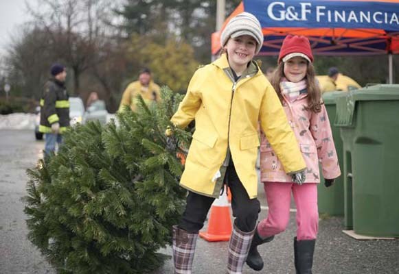 Ready for the chipper: Madelyn Pakulak and sister Olivia drag a tree to the chipper at the New Westminster Firefighters' Charitable Society's annual tree-chipping event. The event raises funds for the charitable society, which donates to a variety of local causes and groups.
