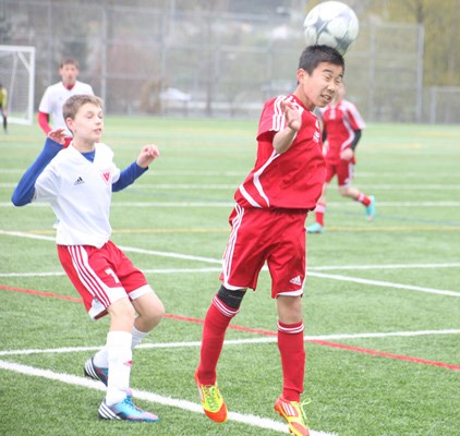 Using his head: Tak Tasaka (red) of the Burnaby Selects' U14 team head butts the ball during a game against West Vancouver. The Selects beat West Van 4-0 and will advance to the semi-finals of the Coastal Cup this Saturday at 11 a.m. at Burnaby Lake Park against Richmond.