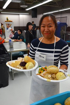 All smiles: Maria, a volunteer, delivers plates to happy diners at the Union Gospel Mission's annual Thanksgiving feast, held on Monday.