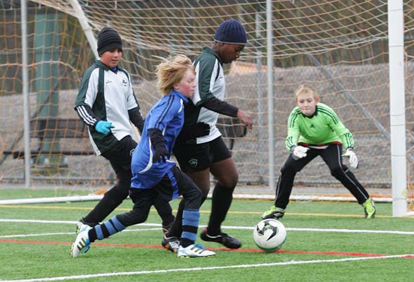 A tall order: Ben Osbourne, in blue, of the Royal City Dominators shared a 3-2 loss to South Burnaby Metro Club in a 4District under-12 gold soccer match at Burnaby Lake Sports Complex-West on Dec. 10.