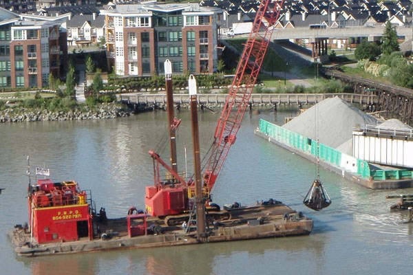 Fraser crane: Extra cranes were brought in on Sunday to begin removing gravel from the barge lodged on the bridge's protection pier. The barge initially hit the bridge on June 28 and the Transportation Safety Board and Transport Canada are currently investigating.