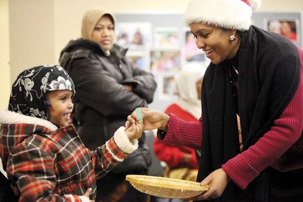 Secret Santa: Farhiya Dahir picks a number for the Secret Santa at a workshop put on by Bitmakaly Women's Association, which was founded by Lubna Abdelrahman (wearing Santa hat).