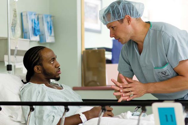 In good hands: B.C. Lions player Stanley Franks talks to Dr. Darius Viskontas at Royal Columbian Hospital. Viskontas was able to reconstruct Franks' injured knee.