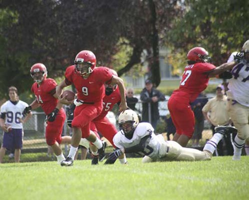 Home turf: Quarterback Mikey Carney, in red, finds some room to run in STM's 14-7 win over Vancouver College in varsity high school football on Saturday.