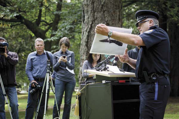 Seeking information: New Westminster Police Service acting Sgt. Bruce Carrie with a picture of the knife used in a July 30 incident in which a police officer was slashed in Queen's Park. Police held a press conference on Thursday in Queen's Park in an effort to raise public awareness of the incident and to get witnesses to come forward.