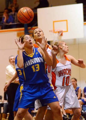 Back on D: First-year Hyack Sharmaine Hayley, in white centre, and teammate Amanda Zacharuk, right, defend against eventual finalist Handsworth on Day 2 of the Telus Basketball Classic at New Westminster Secondary on Dec. 8.