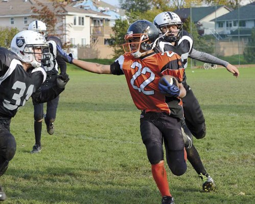 Straight arm: Royal City Hyacks running back Adrian Cagampan, with ball, helped the unbeaten junior bantam team to a one-sided win over the Richmond Raiders in first-round playoff action at Ryall Park last weekend.