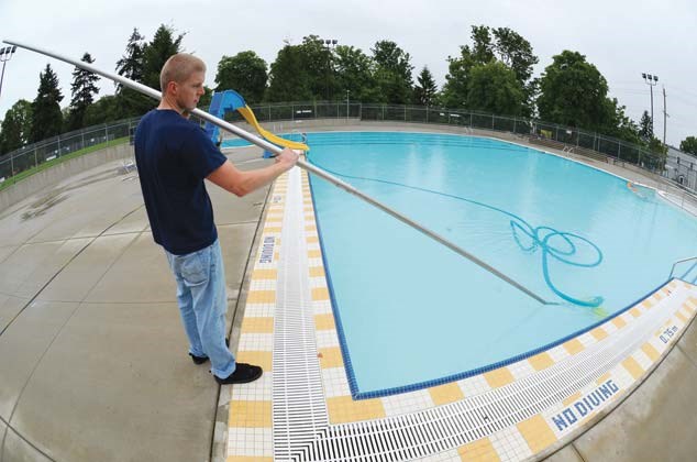 Getting set: Lifeguard Andrew McKinlay checks on the water at Moody Park Outdoor Pool, which opened to the public on Tuesday.