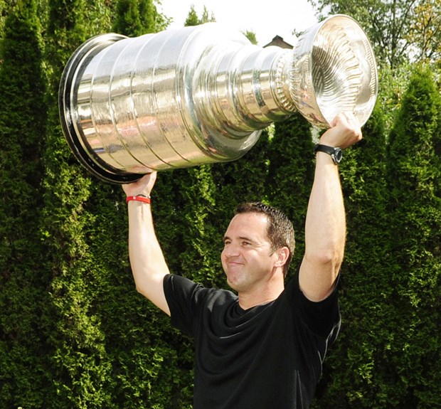 King of the Royal City: L.A.Kings goaltender coach Bill Ranford hoists the Stanley Cup in his New Westminster backyard on Monday afternoon.