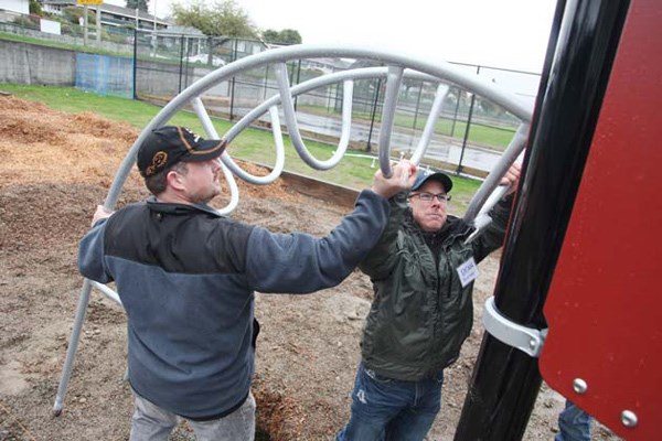 Playtime: Volunteers braved the miserable weather conditions last Saturday to help build the new playground at F.W. Howay Elementary in Massey Heights.