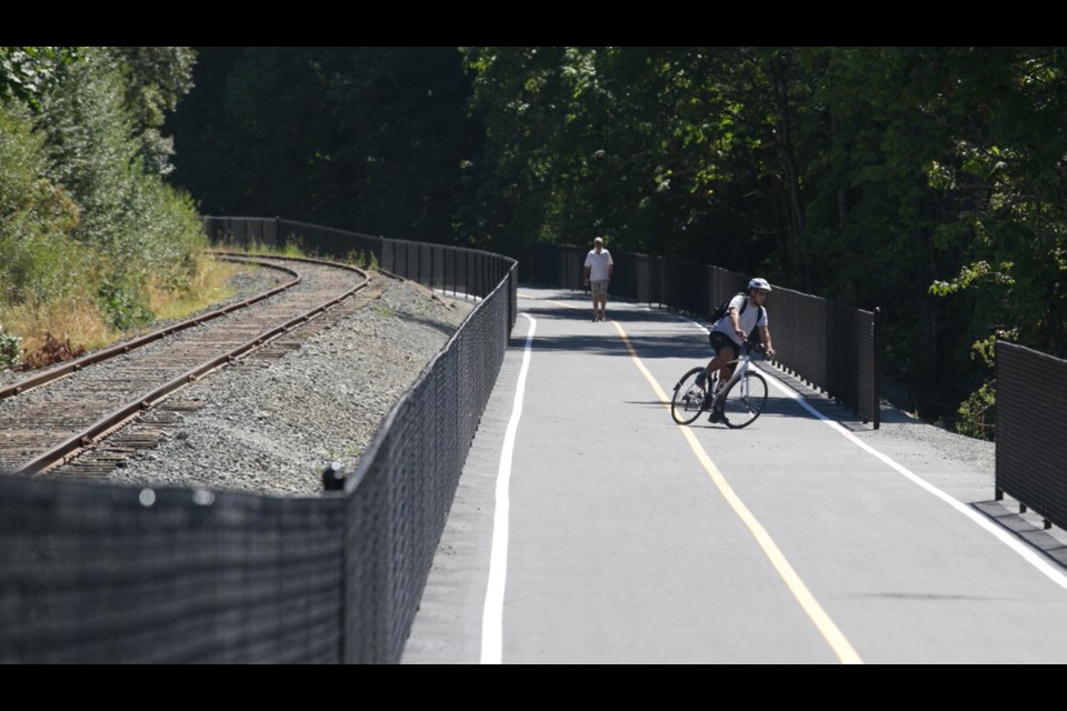 A cyclist and a pedestrian share a section of the E&N Rail Trail near the Four Mile Pub in View Royal.