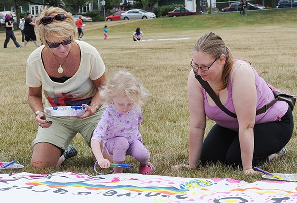Where there's bright paint, there will be children. Katrina Friedman brought her daughter Eleanore Friedman, aged 3, along with Catherine McNeil to McSpadden Park prior to the the noon start of Saturday's Dyke March.