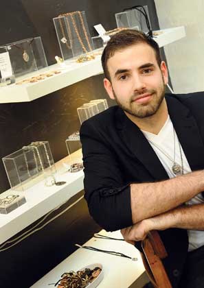 West Vancouver designer and artist Kolton Babych poses with some of his latest jewelry creations during a July 31 opening reception at Tartooful in Edgemont Village.