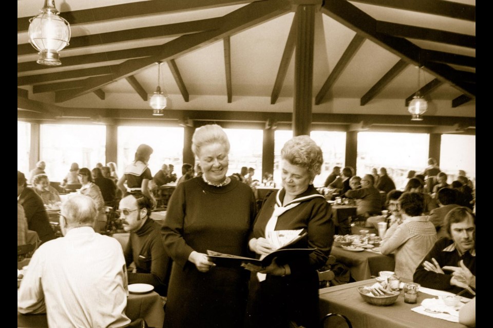 King Neptune: Jean Almas, left, shows the King Neptune Restaurant’s menu to a patron in 1976. The restaurant opened in the late 1950s, but the city did not renew its licence and it floated away.