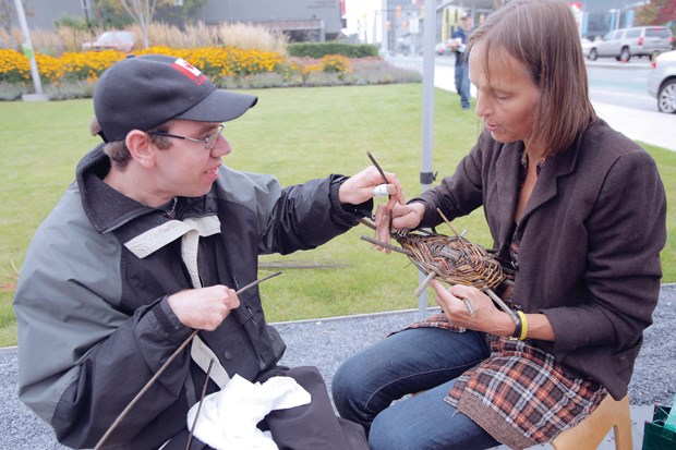Anthony Scorda helps weave a basket bottom with Gundula Kientzler.