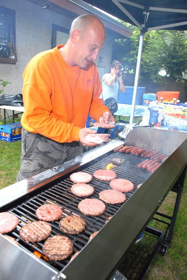 Giving back: Wes Upton, a sales manager at Key West Ford, flips burgers at a barbecue at St. Barnabas Church on Sept. 15. The car dealership sponsored the barbecue and grilled up about 300 hotdogs at the community event.
