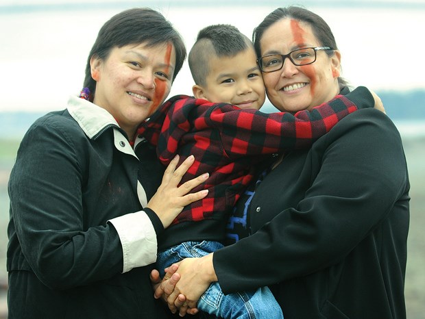 Shelley Joseph, her son Thunder Joseph-Rice and her sister Karen Joseph attend a sacred fire ceremony at Ambleside Monday.