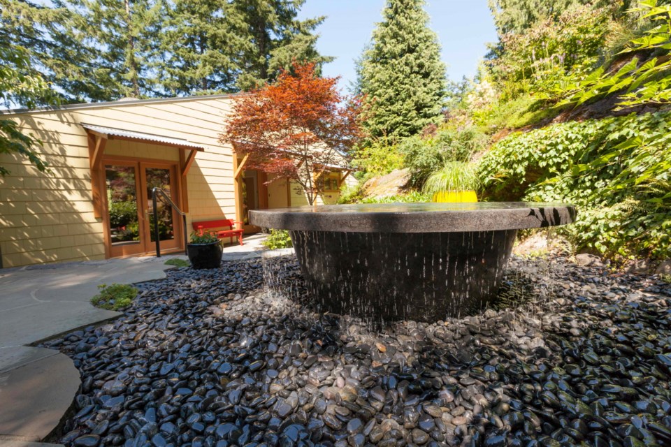 An infinity fountain is the front patio centerpiece of Robin Hill Cottage. The scalloped edge is made with Pennsylvania blue paving stones and polished stones are Mexican.