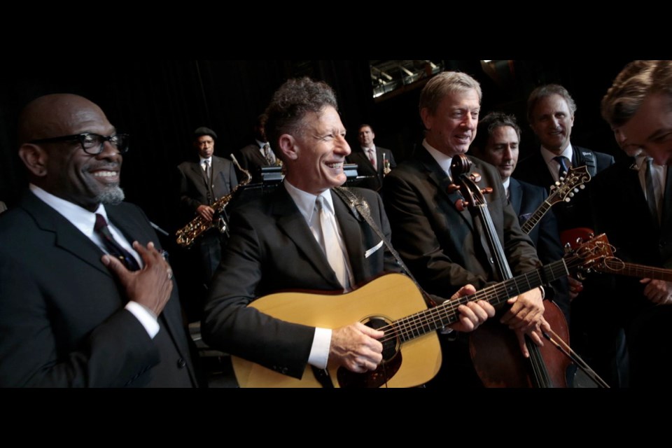 Singer/songwriter Lyle Lovett, with guitar, is adding designer to his job description, teaming with Hamilton Shirts. He is shown with his band at Wolf Trap in Virginia a month ago.