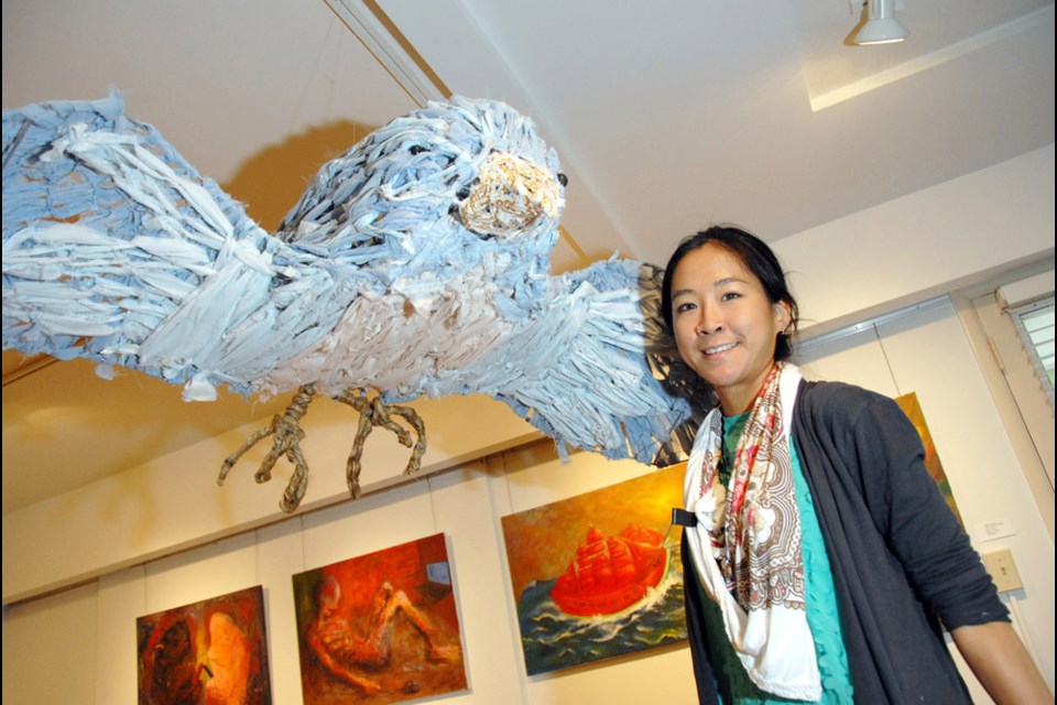 Fly away: Olive Leung, the Burnaby Arts Council's artist in residence, displays her bird, created from recycled material, at the Deer Lake Gallery.
