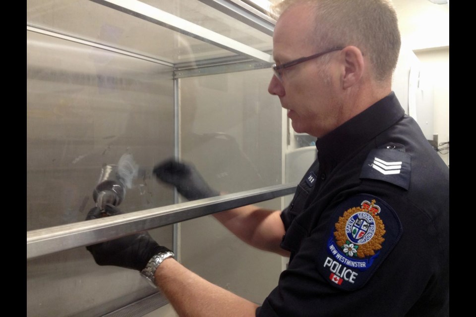 Fine fingerprint work: Acting Sgt. Dwayne Raymond dusts a beer bottle for prints. Raymond came to the department in 2009 and has been helping develop the forensic section since 2010, when he was appointed acting sergeant.