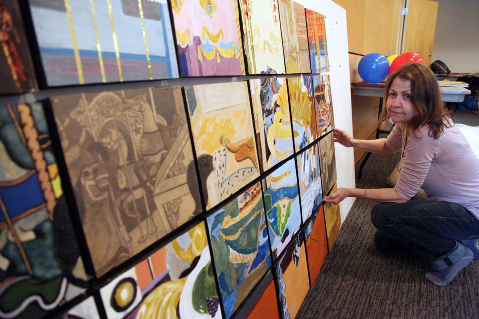 Artist's vision: Cathy placing some of the paintings on the wall at the Express Yourself art show at the Shadbolt Centre Oct. 5.