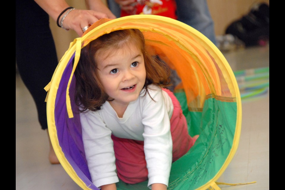 Hello there: Victoria Flouret, almost 2 years old, tries out the tunnel during an obstacle course in Toddler's First Dance class at Cameron Rec Centre.
