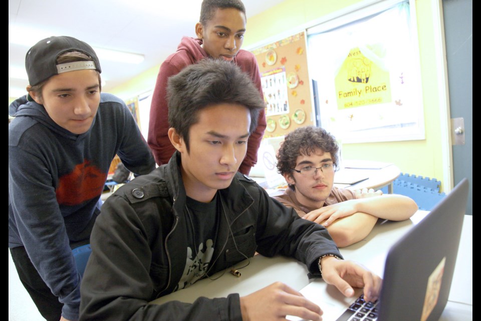 Pulling it together: Jethray Tecson edits on the laptop while (from left) Jacob Dabic, Joey Chandler and Phelan Glenn help out. The three were taking part in a video-making workshop with ReelYouth at Lord Kelvin School, part of the United Way's Care to Change video competition. The team won a special mention for humour in the contest awards, presented Feb. 16.