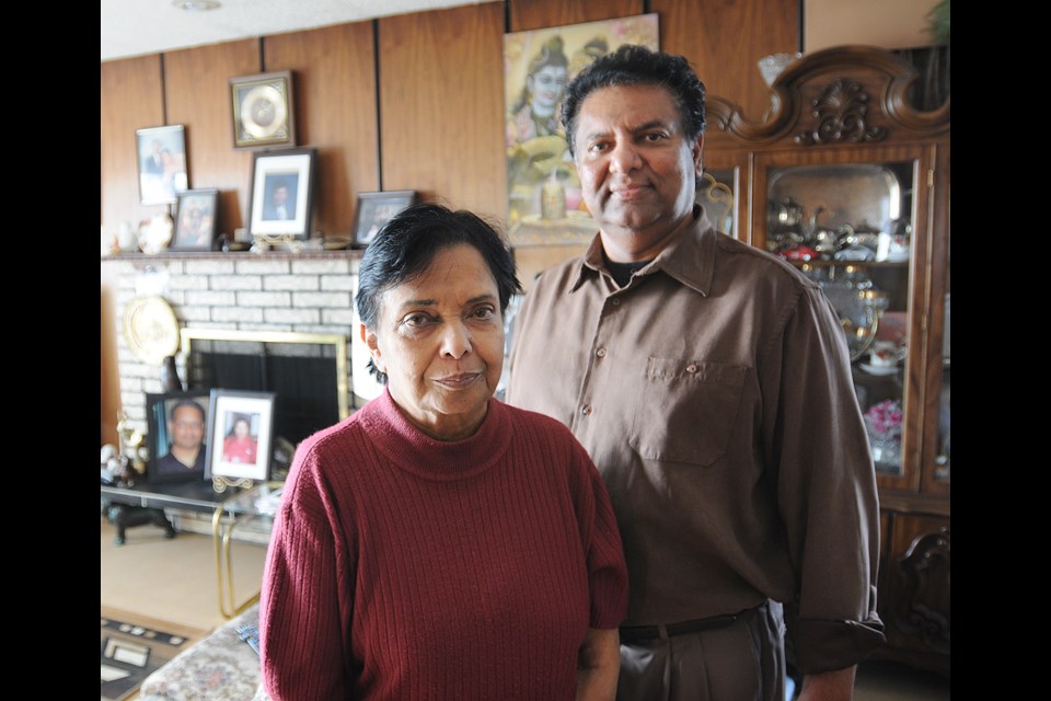 Kamla Prasad (l) and her son-in-law, Ahmed Buksh stand in the living room of the house Prasad has lived in since 1973 at 1017 Marine Drive. photo Dan Toulgoet