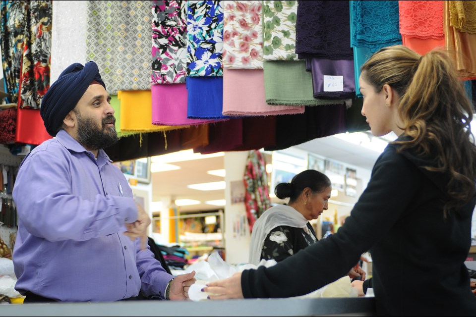 In the latest instalment of our Vancouver Special neighbourhood series, we profile Sunset, where you’ll find Jas Khurana helping customers like Neda Emaniat at his shop Rokko Sarees & Fabrics on Fraser Street. photo Dan Toulgoet