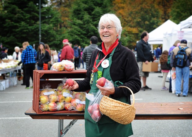 Friends of the Garden member Margaret Butschler with a bag of Okana apples for sale during Saturday morning’s Apple Festival at the University of BC. Photograph by: Rebecca Blissett