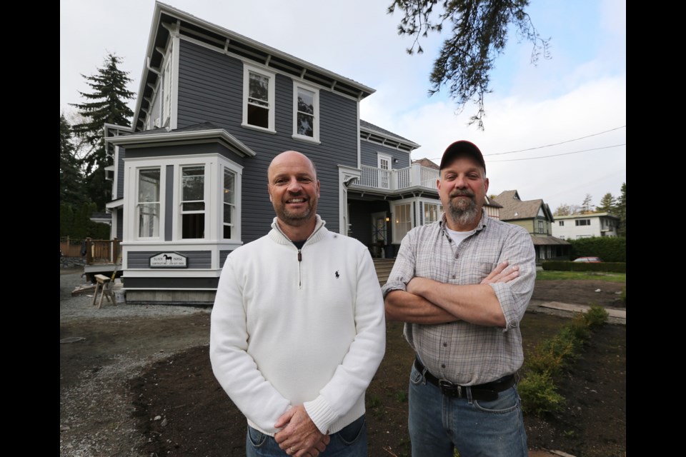 Harry Newton of Newtco Realty, left, and Mike Sweet of Black Horse Contracting pose in front of the apartment building they moved from the corner of Richmond and Oak Bay Avenue to 1016 Pemberton Rd.