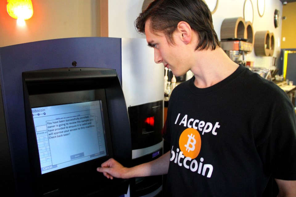 Gabrial Scheare uses the world's first bitcoin ATM at a downtown Vancouver Waves Coffee House on Oct. 29. Scheare, told reporters he came down to "be a part of history." The ATM, developed by Las Vegas-based RoboCoin, allows users to convert cash into the bitcoins and vice versa. The world's most popular digital currency is starting to hit the mainstream, as a growing number of local retailers are now taking bitcoins as payments. Jared Gnam