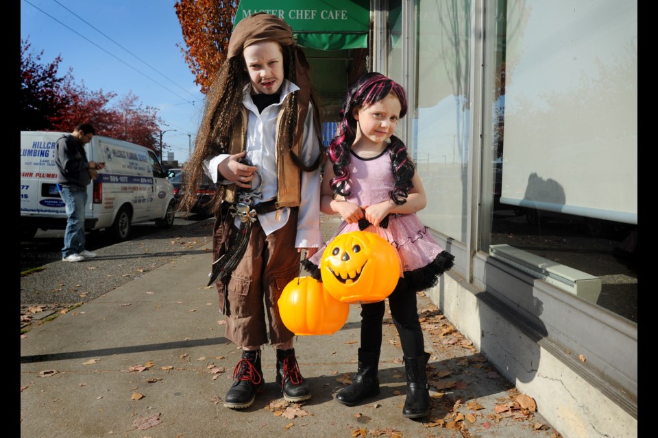 Pirate Jack Erquicia, 6, poses with pretty-in-pink sister Ivy Erquicia during trick-or-treating in the Hastings neighbourhood Saturday afternoon. Photograph by: Rebecca Blissett